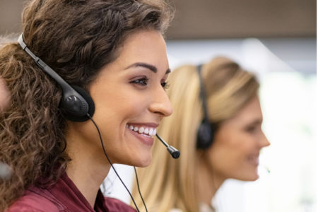 Two women answer phone calls for healthcare providers.