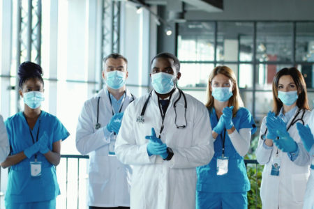 Doctors and nurses applauding in a hospital